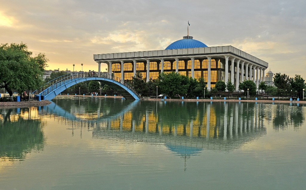 A palatial building and lake in Tashkent at sunset